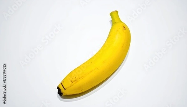 Obraz Bright yellow banana on a white background, with curved shape and small spots