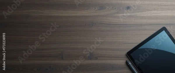 Fototapeta Dark wooden table surface featuring a digital tablet and stylus Extensive empty copy space is available