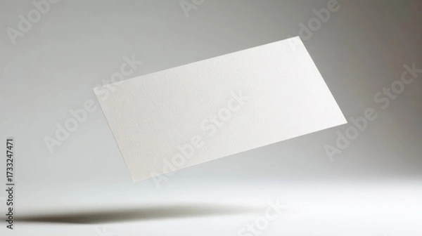Obraz A single white rectangular paper floats horizontally against a light grey gradient background,