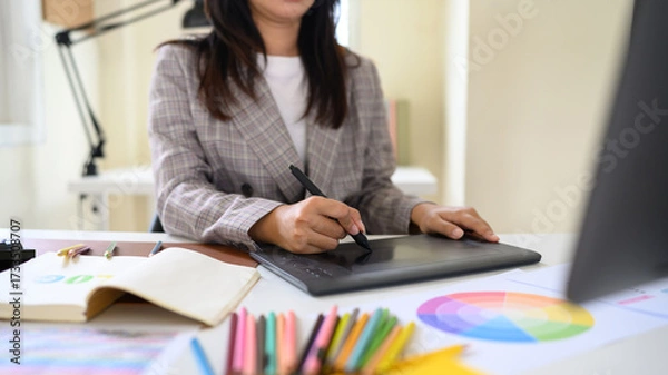 Fototapeta Professional artist working on digital design project with stylus pen and color palette in creative studio workspace