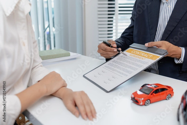 Fototapeta Business negotiation for car purchase shown with toy car models, car keys, calculator, and contract agreement. The images illustrate consultation, signing process, and financial decision.