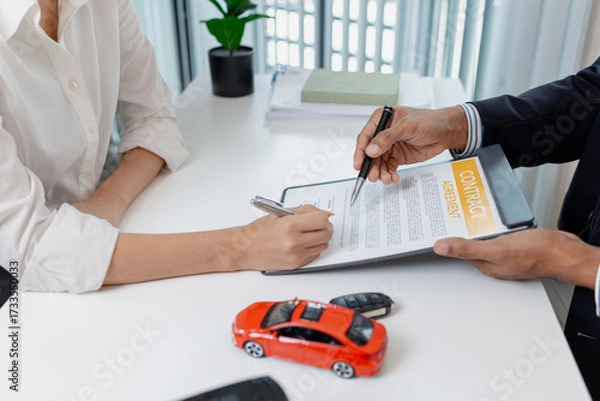 Fototapeta Business negotiation for car purchase shown with toy car models, car keys, calculator, and contract agreement. The images illustrate consultation, signing process, and financial decision.
