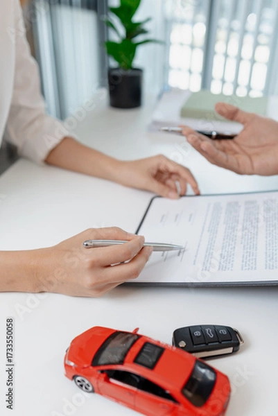 Fototapeta Business negotiation for car purchase shown with toy car models, car keys, calculator, and contract agreement. The images illustrate consultation, signing process, and financial decision.