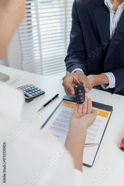 Fototapeta Business negotiation for car purchase shown with toy car models, car keys, calculator, and contract agreement. The images illustrate consultation, signing process, and financial decision.