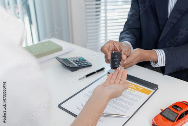 Fototapeta Business negotiation for car purchase shown with toy car models, car keys, calculator, and contract agreement. The images illustrate consultation, signing process, and financial decision.