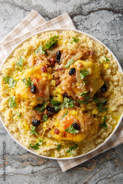 Obraz Moroccan Tfaya Couscous With Braised Chicken closeup on the plate on the table. Vertical top view from above