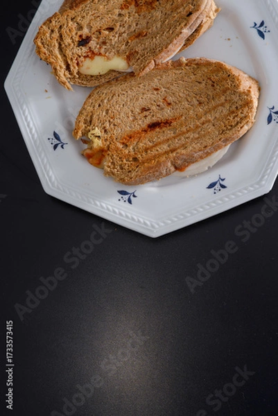 Fototapeta Sandwiches made of homemade bread toasted with ham, spreadable cheese and ketchup inside. Homemade food that is always good to start or end the day.