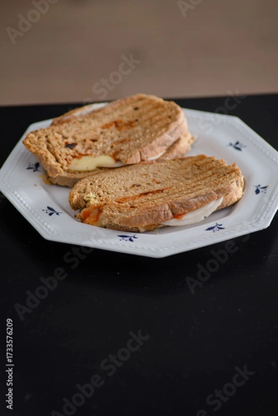 Fototapeta Sandwiches made of homemade bread toasted with ham, spreadable cheese and ketchup inside. Homemade food that is always good to start or end the day.