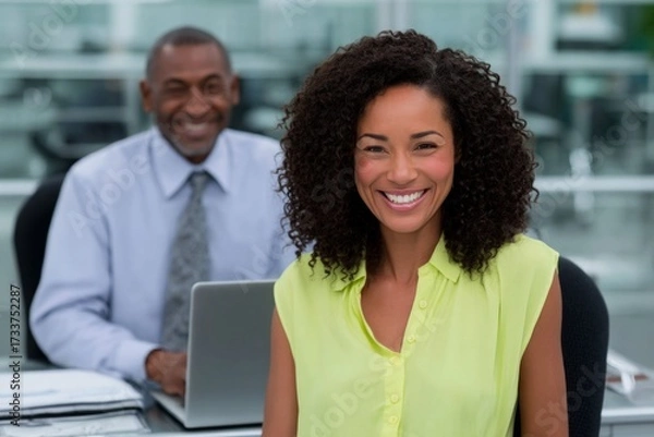Fototapeta Smiling african american businesswoman and colleague in office setting