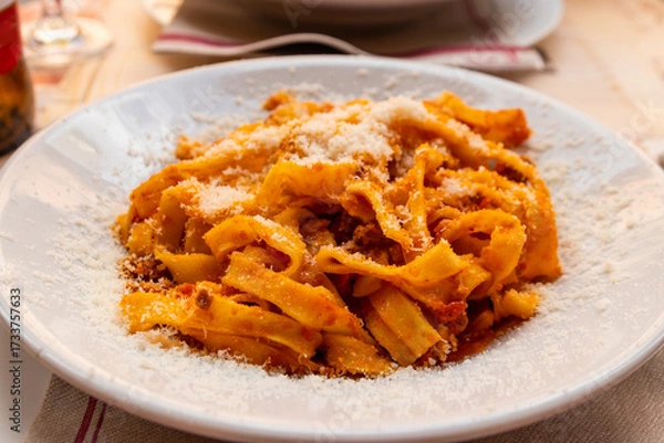 Fototapeta Tagliatelle pasta with bolognese sauce and grated cheese on a table