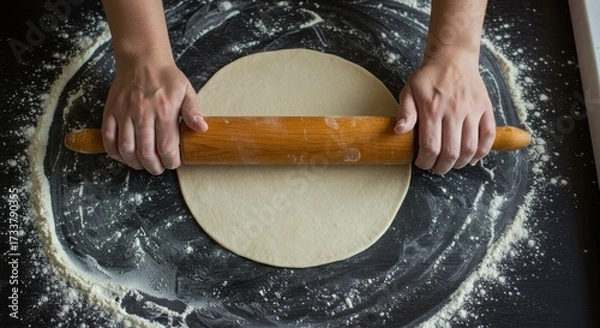 Fototapeta Top View of Hands Rolling Out Homemade Pizza Dough on a Floured Surface
