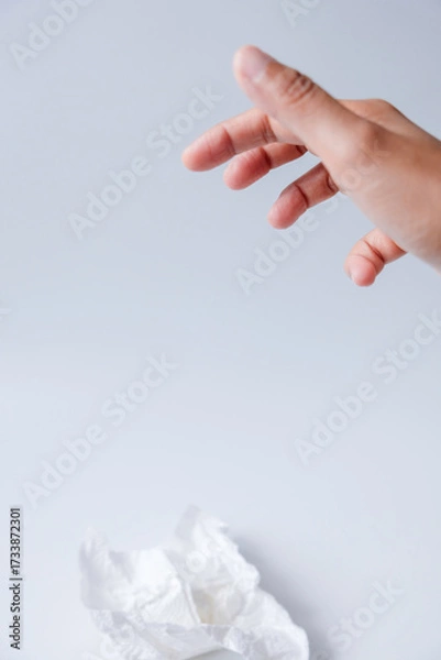 Fototapeta Hand throwing used tissue isolated on white background