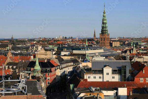 Fototapeta Panoramic aerial view of the city center of Copenhagen (Denmark) with views of the many spires, the Vor Frelsers Kirke church and the Oresundsbroen bridge in the background