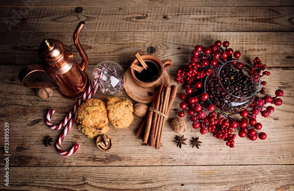 Fototapeta Coffee with cookies cinnamon and spice on old wooden board in rustic style, top view. Christmas composition with baking and hot drink in cup
