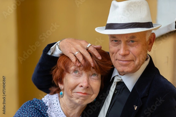 Fototapeta Elderly couple engaged in warm embrace while enjoying a moment of affection in a cozy setting