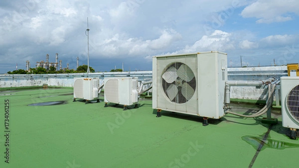 Fototapeta Windows-type air conditioners installed on the rooftop of a building, symbolizing cooling technology, energy management, urban infrastructure,