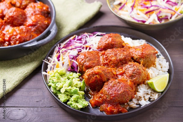Fototapeta Colorful and appetizing plate of homemade meatballs served with with rice, avocado and creamy coleslaw