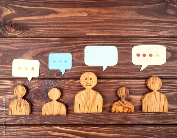 Obraz Wooden figures with speech bubbles on a wooden background