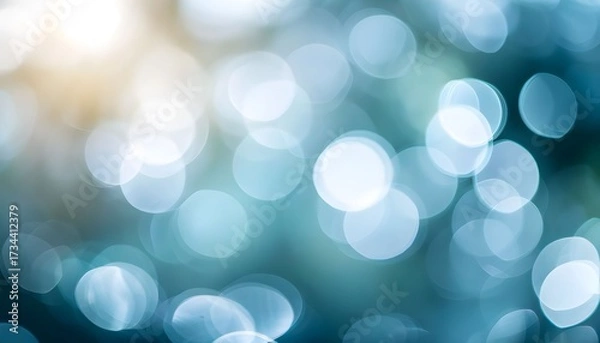 Fototapeta A beautiful abstract background of shimmering blue and white bokeh lights with a warm golden glow.