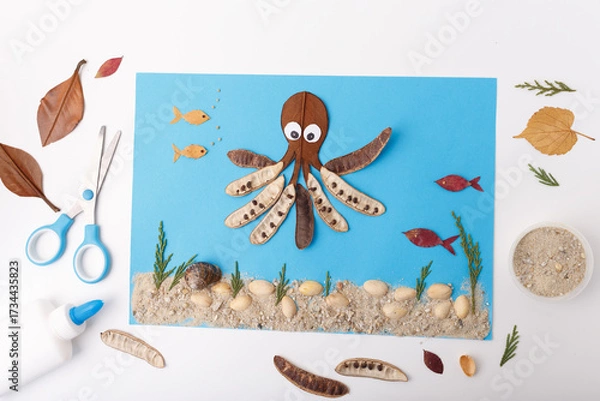 Fototapeta diy creative flat lay tutorial collage with octopus and fish from leaves pods seeds on blue background underwater project activity for kids useful for eco campaigns children learning publishing,