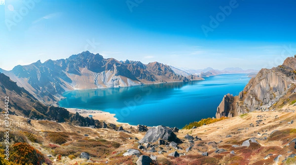 Obraz The Changbaishan Tianchi: A Majestic Volcanic Crater Lake on the China-North Korea Border in Jilin, China—Boasting Crystal-Clear Blue Water, Surrounded by Snow-Capped Peaks & Coniferous Forests, Ideal
