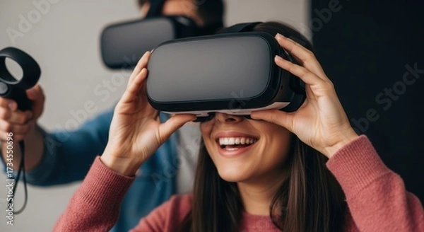 Fototapeta Young adults enjoying virtual reality experience with headsets and controllers