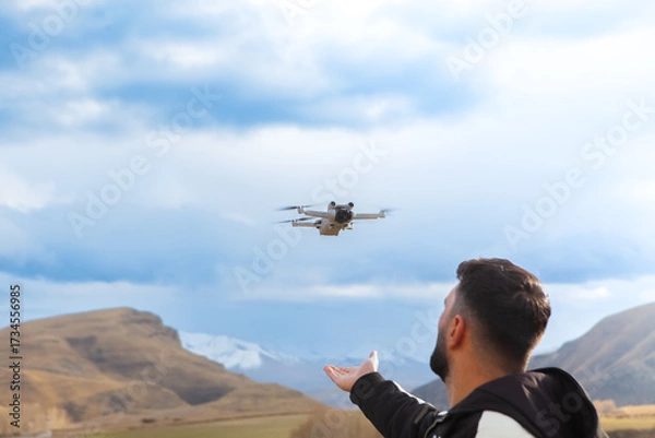 Fototapeta Drone flying in the sky over the mountains. The concept of remote control.