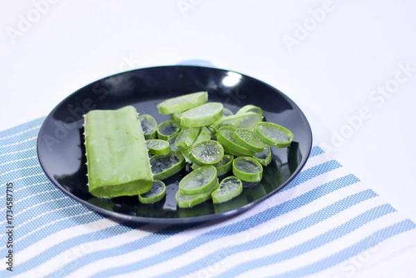 Fototapeta Sliced Aloe Vera in a Black Plate on a Placemat with a White Background