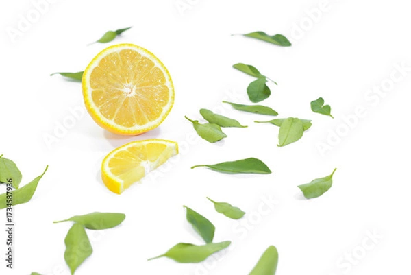 Fototapeta Halved and Sliced Lemons with Leaves on a White Background