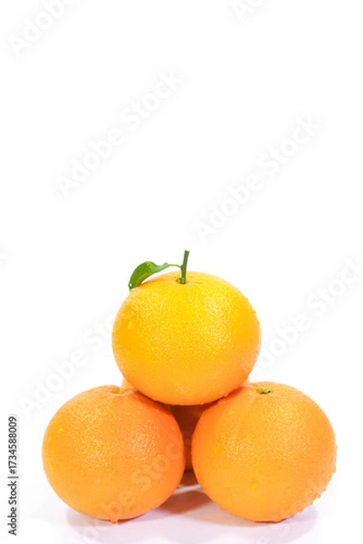Fototapeta Four Valencia Oranges with a Leaf Arranged in a Pyramid on a White Background