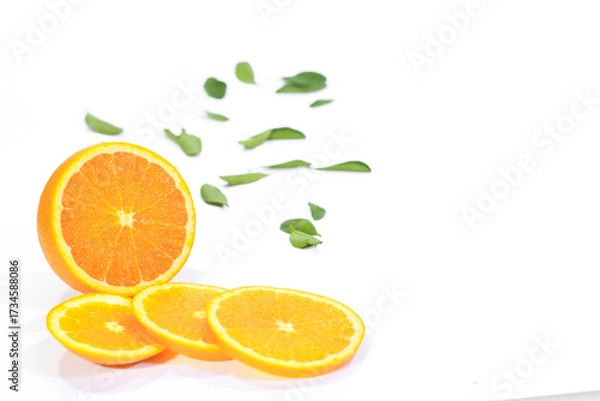 Fototapeta Whole and Sliced Valencia Orange with Leaves on a White Background