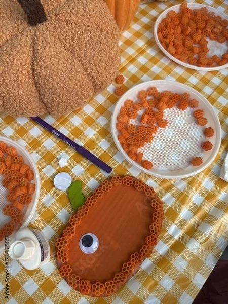 Fototapeta A master class on making pumpkin crafts at a beautifully decorated table for Halloween