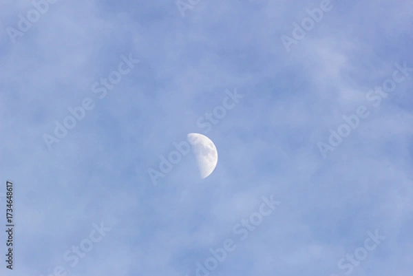 Fototapeta Moon in the blue sky with white clouds, 