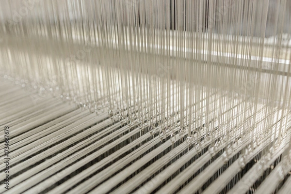 Fototapeta Modern jacquard loom heddles and warp threads in textile manufacturing