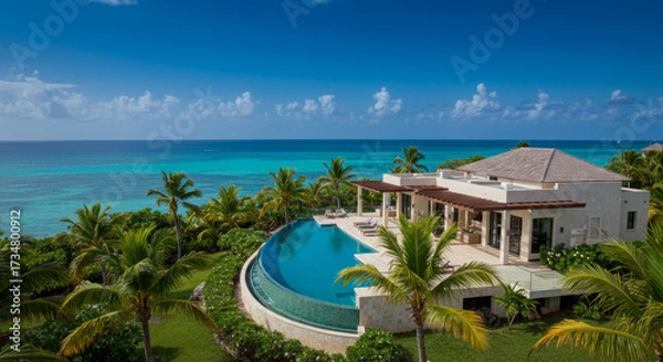 Fototapeta Luxurious Tropical Villa With Infinity Pool Overlooking Turquoise Ocean and Lush Palm Trees