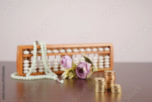 Fototapeta wooden abacus and pile of coins for islamic finance concept
