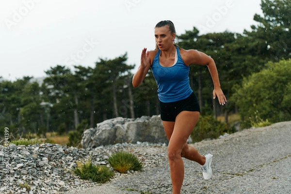 Fototapeta Unstoppable: A Determined Athlete Trains Through the Rain in Pursuit of Marathon Glory
