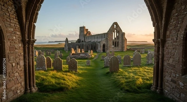 Obraz Ancient stone abbey ruins at sunset framed by archways and grassy landscape