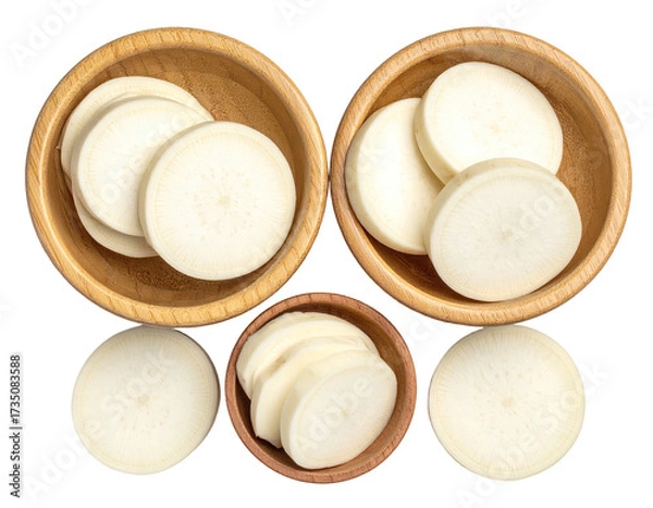 Fototapeta Sliced white root vegetable in wooden bowls arranged against a black background