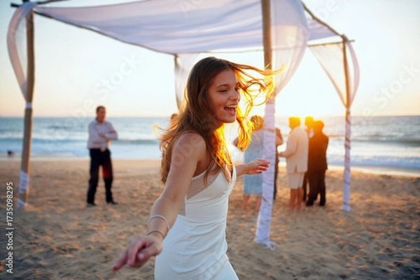 Fototapeta A joyful woman in a white dress dances on the sandy beach during a wedding ceremony as the sun sets over the ocean, surrounded by happy guests. Generative AI.