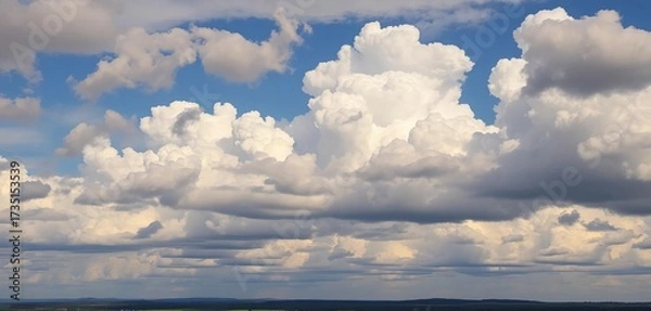 Fototapeta Dense cumulus clouds fill the frame, casting shadows on the landscape below,  white,  spring