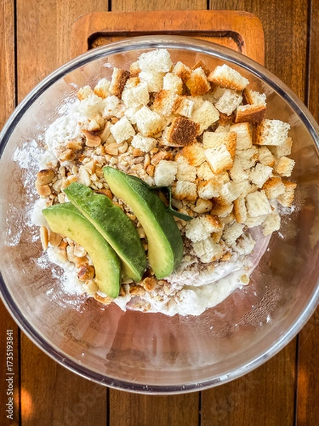 Fototapeta Refreshing Indonesian iced dessert "Es Campur" served in a glass bowl with avocado, jelly, bread cubes, and shaved ice. A colorful tropical treat perfect for hot days.