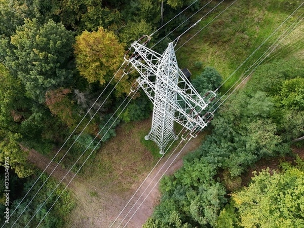 Fototapeta Aerial Drone View of High-Voltage Power Line Tower in Forest Landscape