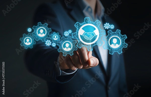 Obraz Connecting Teams Through Digital Partnership Interface, Finger points to handshake icon in gear network of user profiles