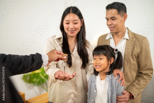 Fototapeta Key handover: Family receives the key of their new house or property, symbolizes a new beginning and the achievement of a life goal.