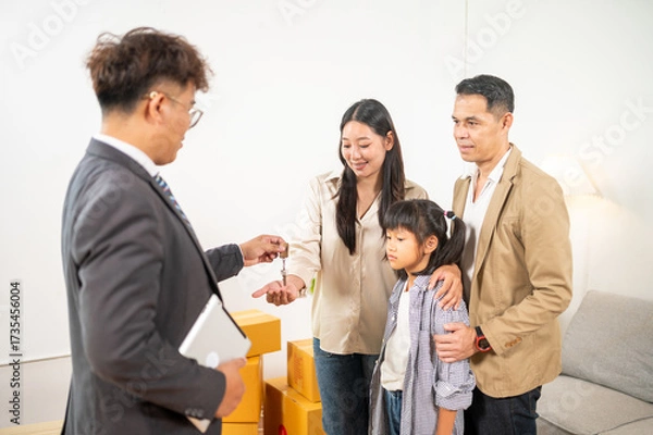 Fototapeta Dream Home handover: A family's excitement soars as they receive house keys from a professional real estate agent, symbolizing a significant moment in their lives. symbolizing the milestone moment.