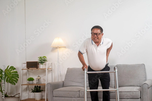 Fototapeta Senior with Mobility Aid: An elderly gentleman, supported by a walker, grapples with back pain and struggles for mobility. An image that speaks volumes about resilience, aging.