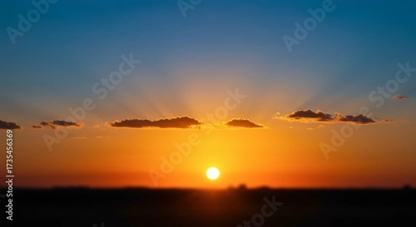 Fototapeta Vibrant sunset landscape with dramatic light and clouds over a silhouette horizon suitable for various applications