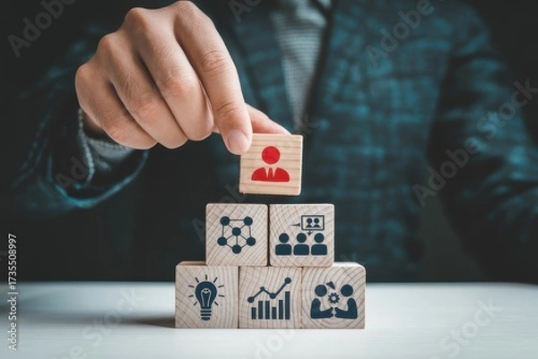 Fototapeta A hand preventing falling dominoes from hitting human figures, symbolizing proactive risk management, intervention, and crisis prevention for business and personal security