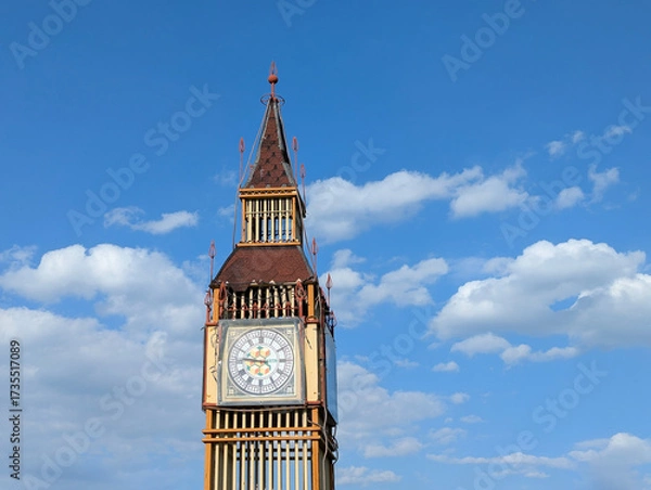 Fototapeta Big Ben tower as a scale model of a building of Houses of Parliament and Westminster pier. An imitation of the exterior of a famous building. A lightweight structure built on a flowerbed.